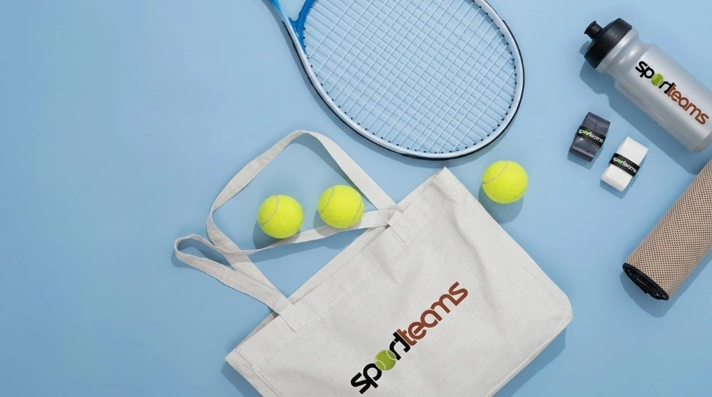 Mockup Merchandising Deportivo: Bolsa tote bag de tela, raqueta de tenis y pelotas sobre fondo celeste.